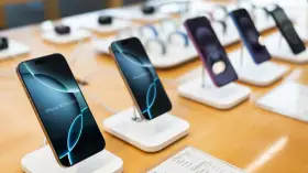 Flera iPhones visas upp på en disk, redo för den som vill byta iPhone. En iPhone 16 Pro Max syns tydligt.