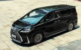 Elegancki, czarny Lexus LM 350h lśni na tle jasnej kostki brukowej.