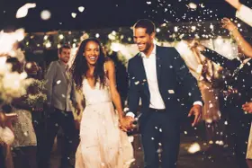 Un couple rayonnant traverse une pluie de pétales, une animation surprise mariage parfaite pour célébrer leur amour.