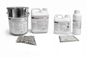 Zestaw produktów do podłóg: duży metalowy pojemnik, dwie plastikowe bańki i dwie paczki z materiałami sypkimi. To wszystko to wysokiej jakości żywica.