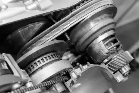 Zbliżenie na mechanizm bezstopniowej skrzyni biegów z widocznym pasem i kołami pasowymi.