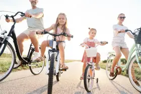 Rodzina na rowerach. Czy karta rowerowa jest obowiązkowa? Dzieci i rodzice cieszą się wspólną przejażdżką.
