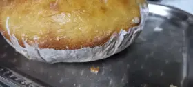 Goldbrauner Teig klebt am Backpapier, das auf einem Metallblech liegt. Ein Teil des Teigs ist bereits abgelöst.