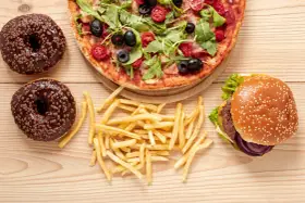 Pizza, burger, frytki i pączki z czekoladą – uczta pełna tłuszczów nasyconych.