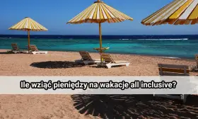 Plaża z leżakami i parasolami pod żółto-białymi pasami, turkusowe morze i błękitne niebo.