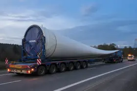 Ogromne łopaty wiatraka Vestas na specjalistycznej platformie. To skomplikowane zlecenie transportowe na drodze o zmierzchu.