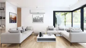 Salón moderno con sofás blancos, mesa de centro y aire acondicionado para la renovación de aire. Ventanal con vistas al jardín.