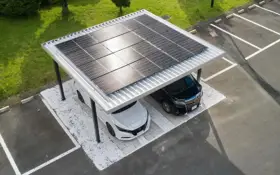 Nowoczesna wiata na samochód z panelami fotowoltaicznymi, chroniąca białe i czarne auto.