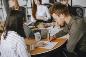 Uomini e donne in riunione, concentrati sul lavoro. Le 40 ore settimanali sono un impegno serio per raggiungere gli obiettivi.
