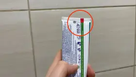 Oznaczenia past do zębów na tubce Colgate. Czerwone kółko podkreśla górną część opakowania.