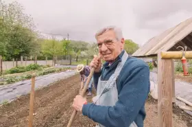 Uśmiechnięty starszy pan z łopatą w ręku, pracujący w ogrodzie. Zastanawia się, jaka emerytura z KRUS po 10 latach będzie mu przysługiwać.