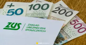 Koperta ZUS z napisem "Zakład Ubezpieczeń Społecznych" na tle polskich banknotów 50, 100, 200 i 500 zł. Symbolizuje świadczenie kompensacyjne.