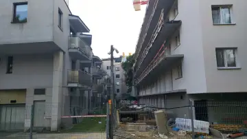 Budowa bloków mieszkalnych, gdzie widać niedokończone balkony i materiały budowlane. Typowa patodeweloperka, która nie budzi zachwytu.