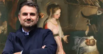 Mężczyzna na pierwszym planie, jakby Melchior z obrazu, stoi przed sceną narodzin Jezusa, z Matką Boską i zwierzętami.