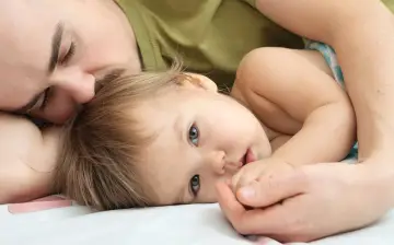 Ojciec tuli dziecko, które ma problemy z refluksem. Czułość i spokój w ich uścisku.