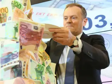 Donald Tusk z talerzem pełnym banknotów euro, symbolizującym przyszłość euro w Polsce.