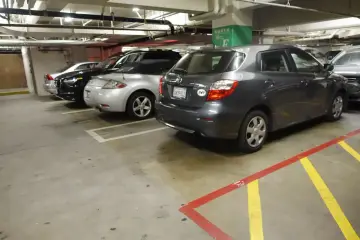 Wspólnota mieszkaniowa: opłaty za garaż. Samochody zaparkowane na podziemnym parkingu, w tym ciemnoszary hatchback.