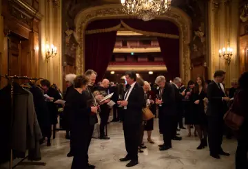 Eleganckie przyjęcie w teatrze. Ludzie rozmawiają, piją wino, zastanawiając się, co to jest antrakt.