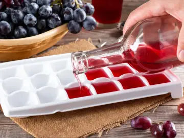 Wino przelewane do pojemnika na lód, by zamrozić je do celów kulinarnych. Skutki mrożenia wina w zamrażarce są widoczne na zdjęciu.