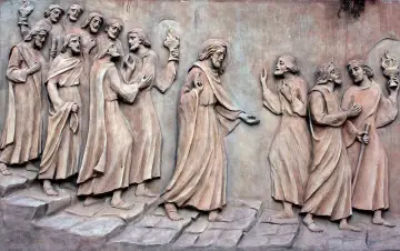 Kamienna płaskorzeźba przedstawia Jezusa w Ogrójcu, otoczonego przez apostołów.