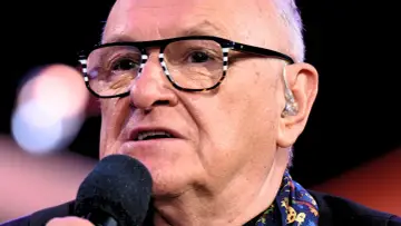 Jacek Cygan w okularach, z mikrofonem i słuchawką w uchu. Jego piosenki alfabetycznie to bogactwo polskiej muzyki.