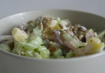 Pyszna sałatka z selerem i ananasem, posypana słonecznikiem. Idealna na lekki posiłek.