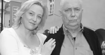 Joanna Kossowska i starszy mężczyzna pozują do zdjęcia. Wiek Joanny Kossowskiej nie jest widoczny, ale widać jej uśmiech.