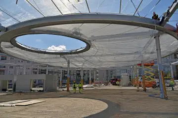 Budowa zadaszenia z folii etfe. Pracownicy w kaskach nadzorują montaż lekkiej, półprzezroczystej membrany.