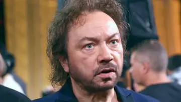 Zbliżenie na twarz mężczyzny z kręconymi włosami i niebieskimi oczami. Czyżby to był Mietek Szcześniak, nasz partner w muzycznej podróży?