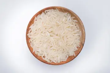 Miseczka z ryżem parboiled na białym tle.