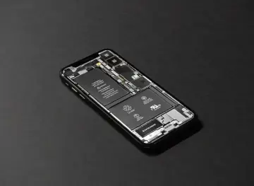 Rozłożony iPhone z widoczną baterią. Kalibracja baterii iPhone może pomóc w przywróceniu jej pełnej sprawności.