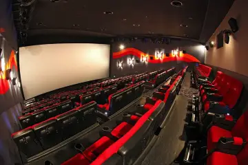 Puste rzędy czerwonych i czarnych foteli kinowych w Cinema City. Zastanawiasz się, ile zarabia się w Cinema City?