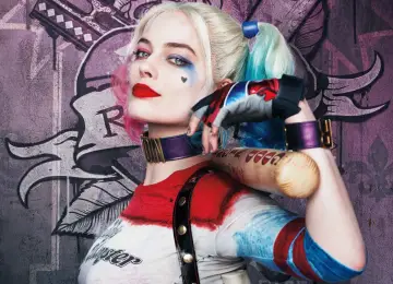 Dziewczyna Jokera, Harley Quinn, z pałką baseballową i charakterystycznym makijażem, pozuje na tle graffiti.