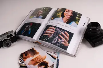 Album na zdjęcia z wakacji, obok aparat fotograficzny. Idealne miejsce na przechowywanie zdjęć i wspomnień.