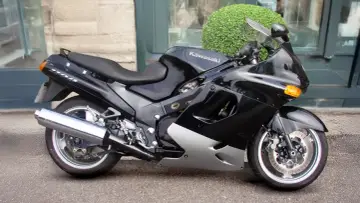 Czarny motocykl Kawasaki ZZR 1100 z błyszczącym chromowanym wydechem, gotowy do podróży.