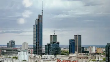 Warszawski drapacz chmur, najwyższy budynek w Warszawie, góruje nad panoramą miasta, otoczony innymi nowoczesnymi wieżowcami.