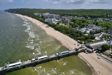 Molo i plaża w kurorcie nadmorskim. Idealne miejsce na jednodniowe wycieczki zachodniopomorskie, z hotelami i lasem w tle.