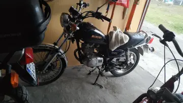 Czarny motocykl Suzuki GN125, gotowy do jazdy. Dane techniczne tego modelu są imponujące.