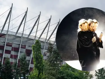 Quebonafide koncert na Stadionie Narodowym. Artysta w czarnym swetrze, z mikrofonem i telefonem w dłoni, na tle sceny.