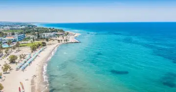 Wyspa Kos oferuje piękne plaże i turkusowe morze. Widok na wybrzeże z hotelami i leżakami zaprasza do wypoczynku.