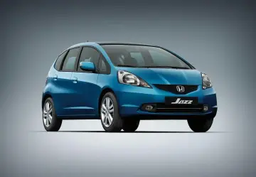Niebieski Honda Jazz 2, miejski samochód z czarnym dachem, prezentuje się elegancko na szarym tle.
