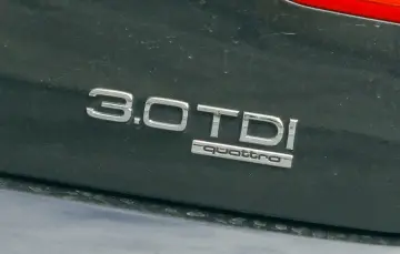 Napis "3.0 TDI quattro" na ciemnym lakierze. Ta pojemność silnika sugeruje moc i osiągi.