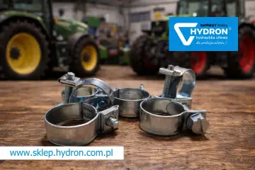 Metalowe opaski zaciskowe, czyli trytytki, na drewnianym blacie. W tle zielone traktory i logo Hydron.