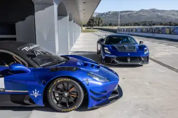 Dwa niebieskie Maserati na torze wyścigowym. Jedno z nich, z bliska, ma na oponach napis Pirelli P Zero.