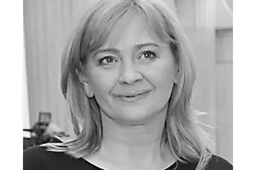 Portret Sylwii Gaj. Uśmiechnięta kobieta o jasnych włosach, uchwycona w czarno-białych kadrach.