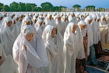 Tysiące kobiet w białych hidżabach modlą się, oddając cześć islam religia.