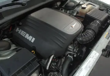 Silnik 5.7 Hemi z napisem HEMI na pokrywie. Widoczny układ dolotowy i inne elementy komory silnika.