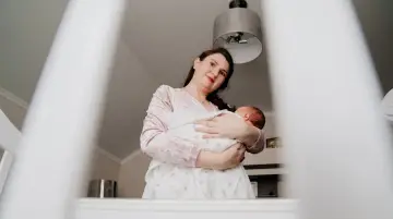 Matka tuli dziecko, które lekko się wierciło, jakby czuło stan podgorączkowy u niemowlaka.