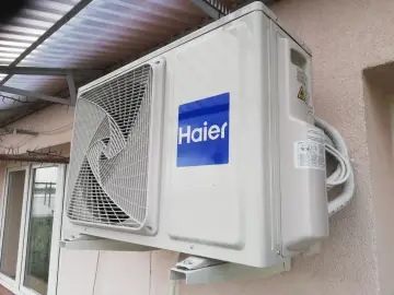 Jednostka zewnętrzna klimatyzacji Haier zamontowana na ścianie budynku.