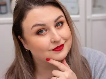 Kobieta z idealnym makijażem wieczorowym: złote cienie, czarna kreska i matowa czerwona szminka.